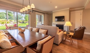A spacious living area with a dining table, sofas, and a fireplace.