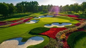 A golf course with sand bunkers, manicured grass, and colorful flower beds. - The Inn at SentryWorld (Stevens Point)