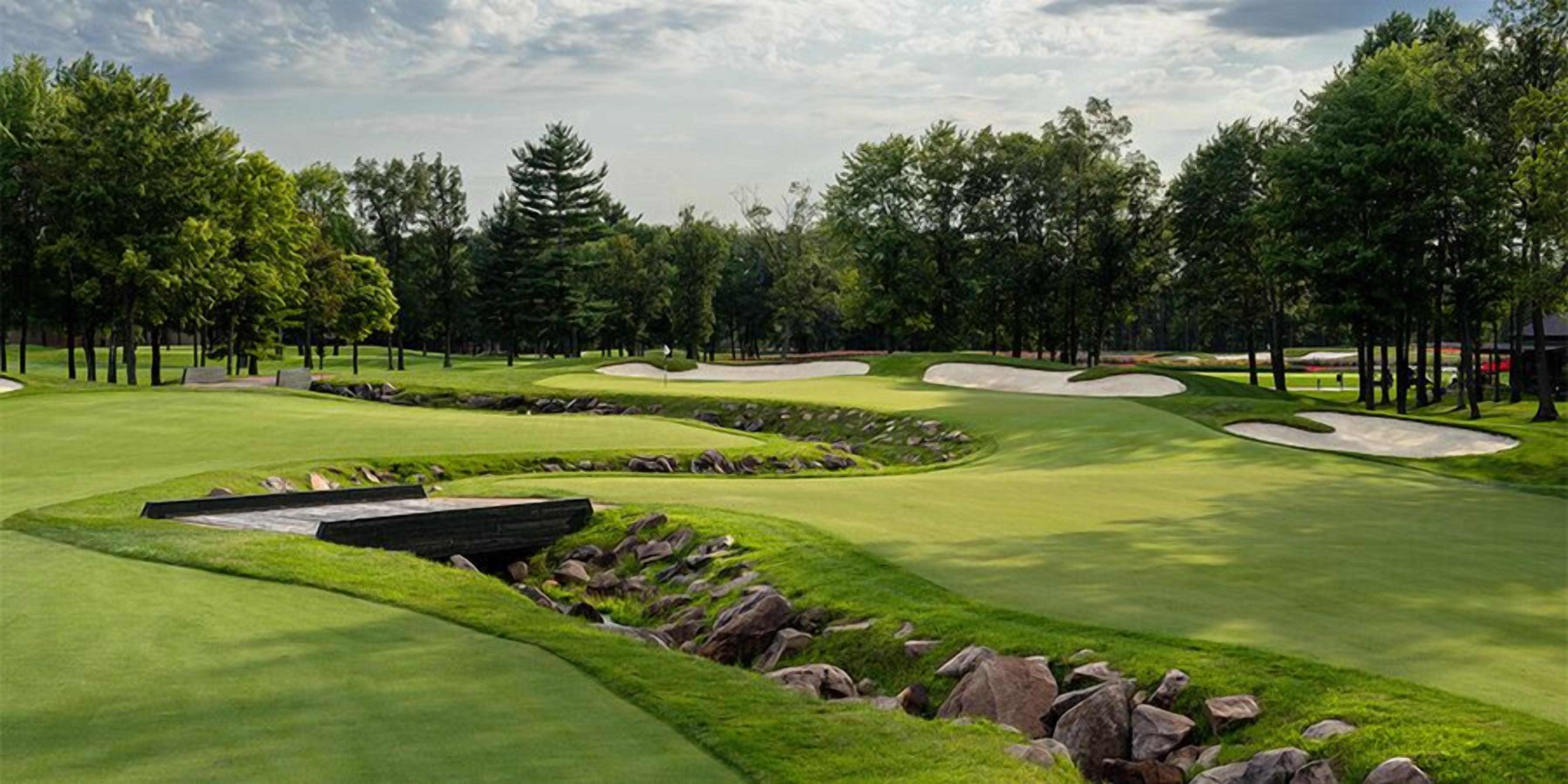 Un parcours de golf doté de bunkers de sable, d’un obstacle d’eau et d’une zone de jeu bien entretenue.