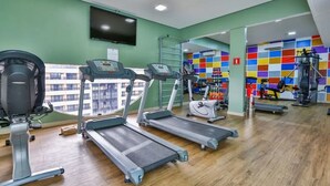 A gym with treadmills, a stationary bike, and a rowing machine. - Saint Paul Plaza Flat Particular (Brasília)