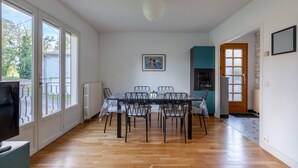 A dining area with a table and chairs, a radiator, and a door leading to another room.