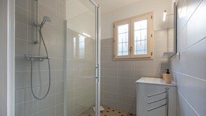 A modern bathroom with a glass shower enclosure, a sink with a mirror, and a cabinet with a window above it. - La maison d'Armand - Maison avec jardin (Vatan)