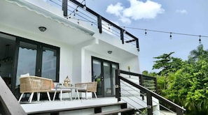 Uma casa moderna com varanda, área de estar externa e escada.