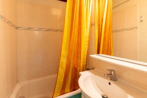 Ein Badezimmer mit Badewanne, Waschbecken und Spiegel.
