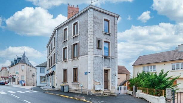Un bâtiment à deux étages, doté d’une façade en pierre, de nombreuses fenêtres et d’une entrée bien visible.
