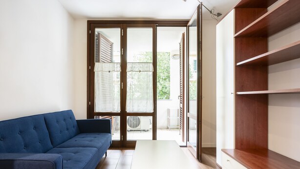 A living room with a blue sofa, a white coffee table, and a wooden cabinet. - Berni - One Bedroom Apartment, Sleeps 2 (Florence)