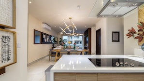 Cozinha moderna com ilha central, armários de madeira e luminária pendente contemporânea.
