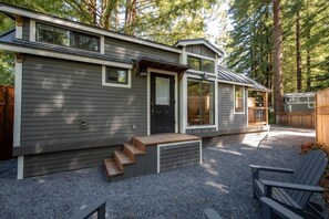 A two-story house with a covered porch and a gravel driveway.