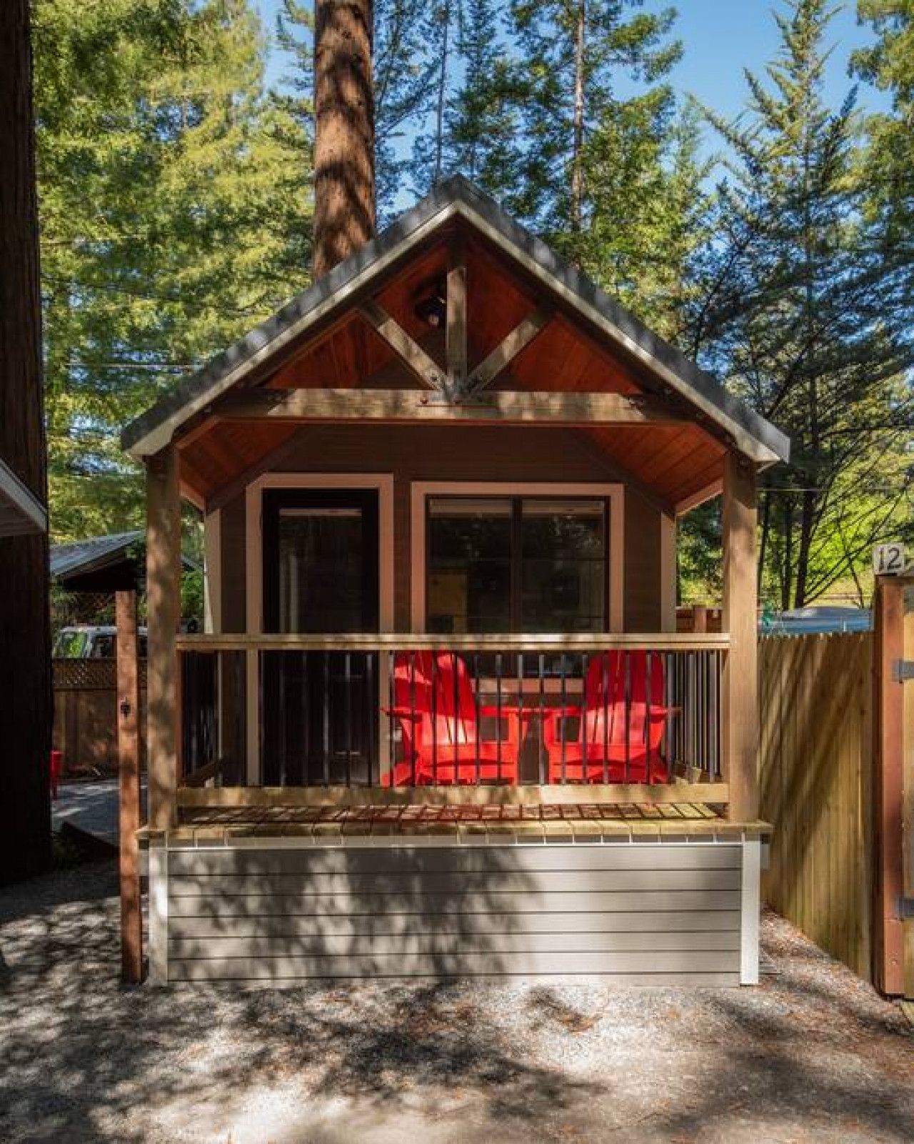 A cabin with a porch, a covered seating area, and a wooden deck.