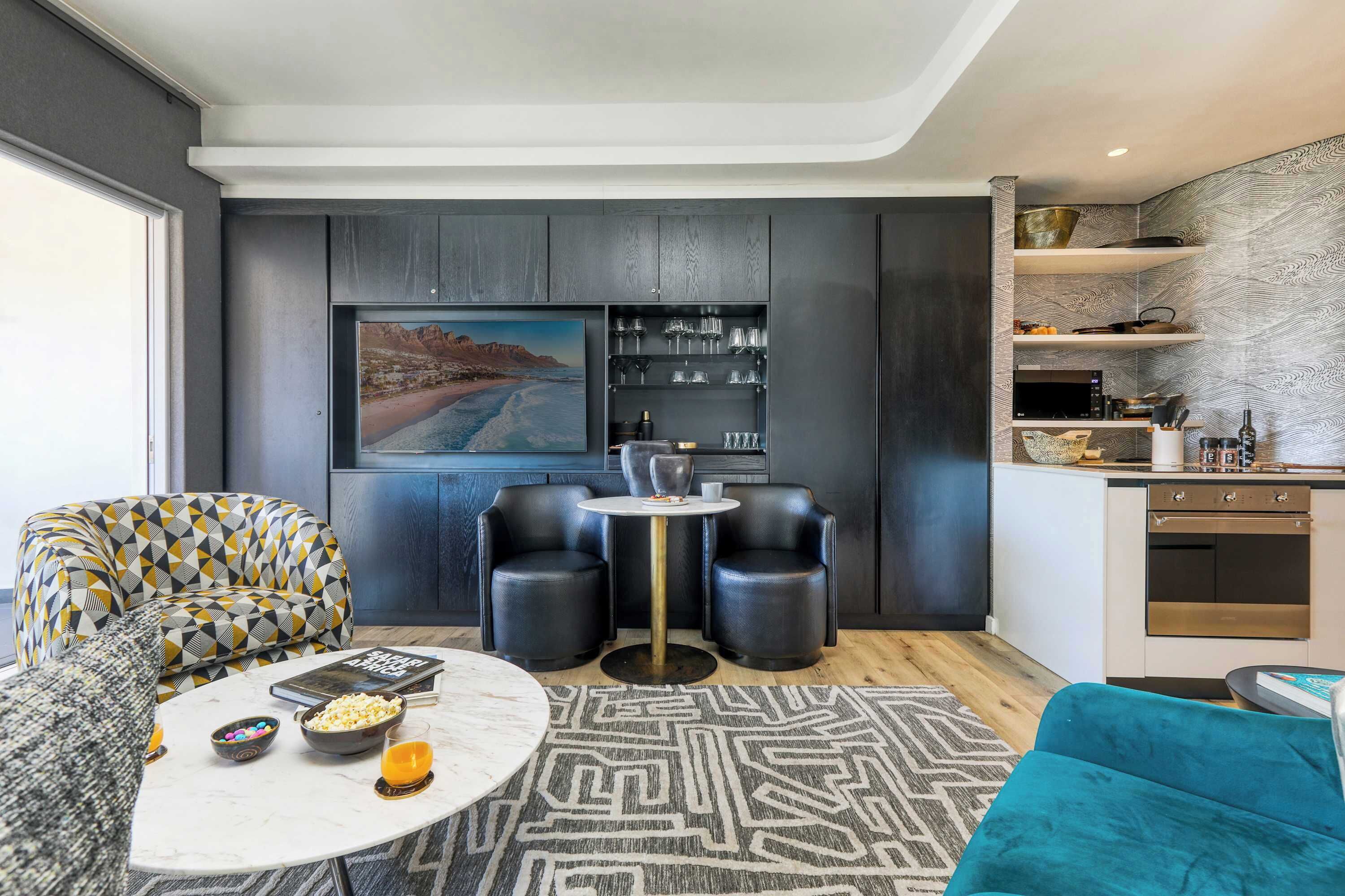Una sala de estar moderna con un sofá, una mesa de centro y una zona de comedor con una pequeña mesa y sillas.