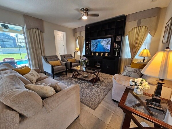 A living room with a sofa set, a coffee table, a TV, and a fireplace.