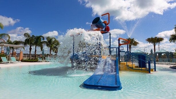 A water play area with a blue slide and a water jet. - Solara Resort private POOL HOME 4 Bed (Kissimmee)