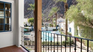 Ein Balkon mit Blick auf einen Pool, Palmen und einem Bergpanorama.
