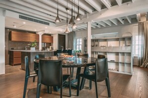 A modern kitchen with dark wooden cabinets, a central island, and pendant lighting.