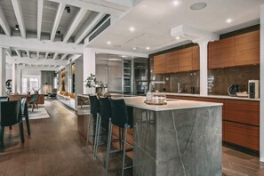 A modern kitchen with a marble island, wooden cabinets, and stainless steel appliances. - Immaculate 2-bed Loft Apartment In Central London (London)