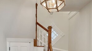 Eine Treppe mit Holzboden und einem Holnänder, die zu einer weißen Tür führt.