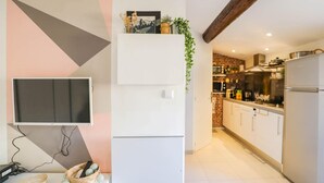 A modern kitchen with white cabinets, a built-in microwave, and a stainless steel refrigerator.
