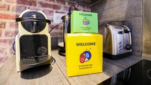 A kitchen counter with a coffee maker, a toaster, and a cleaning kit box.