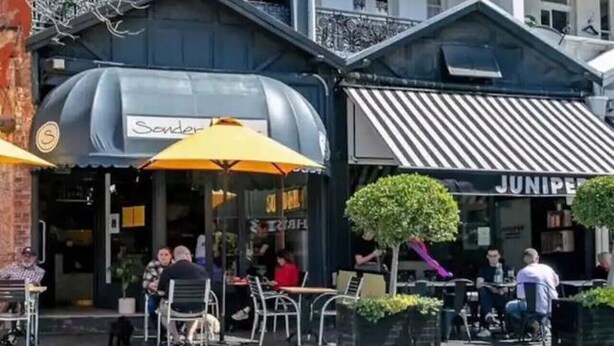 A street with outdoor seating, a building with a striped awning, and a sign that reads 'Juniper.' - Peaceful & Light Paddington home (Paddington)