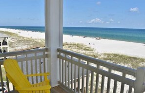 A beach view from a balcony with a yellow chair and a railing. - Lemonshello BeachFront, Hot tub, Heated Pool, 8 bedrooms (Gulf Shores)