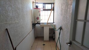 A narrow stairway with a water heater, a sink, and a door. - Cozy Villa in Almoloya de Juárez, Mexico (Almoloya de Juárez)