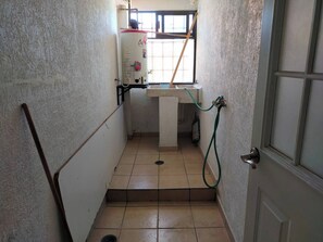 A narrow stairway with a water heater, a sink, and a door. - Cozy Villa in Almoloya de Juárez, Mexico (Almoloya de Juárez)