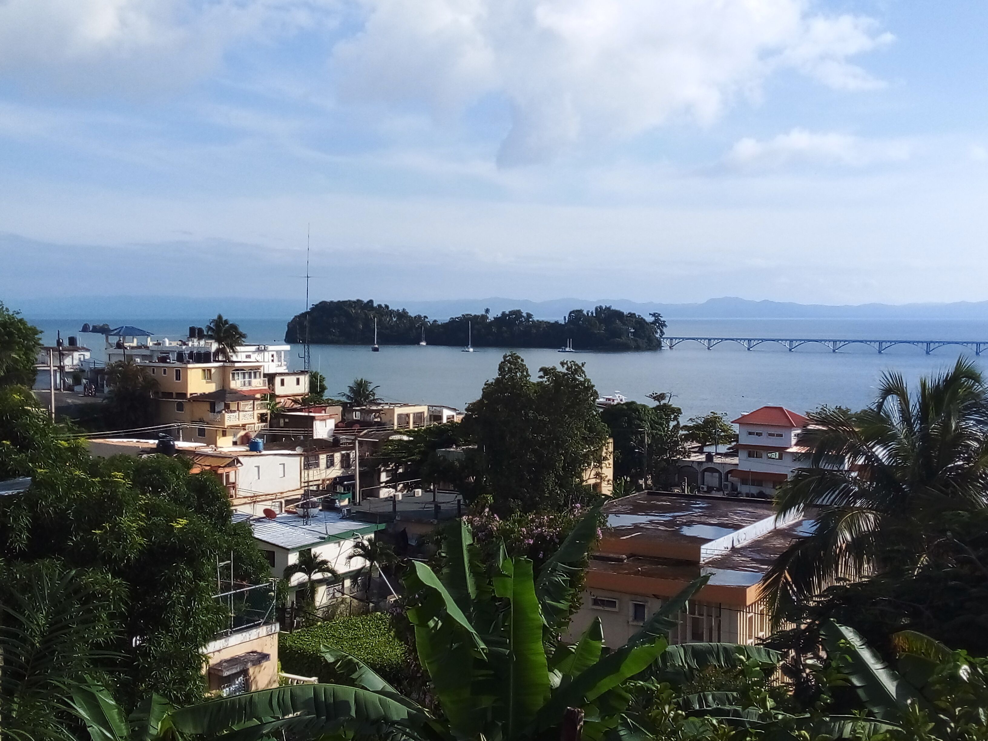 A coastal town with buildings, a bridge, and a body of water.