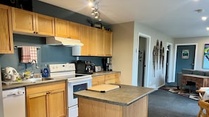 A modern kitchen with wooden cabinets, a built-in oven, a coffee maker, and a toaster.