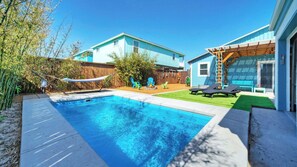 Un pati amb una piscina, una cadira espanyola i mobiliari d'exterior.