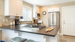 Una cocina moderna con una isla central, electrodomésticos de acero inoxidable y un refrigerador grande.