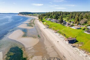 Una propiedad costera con playa, casas y zona boscosa.