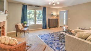 A living room with a fireplace, a sofa, a coffee table, and a patterned rug. - Best of the Blue Ridge by Avantstay A+ Location (Arden)