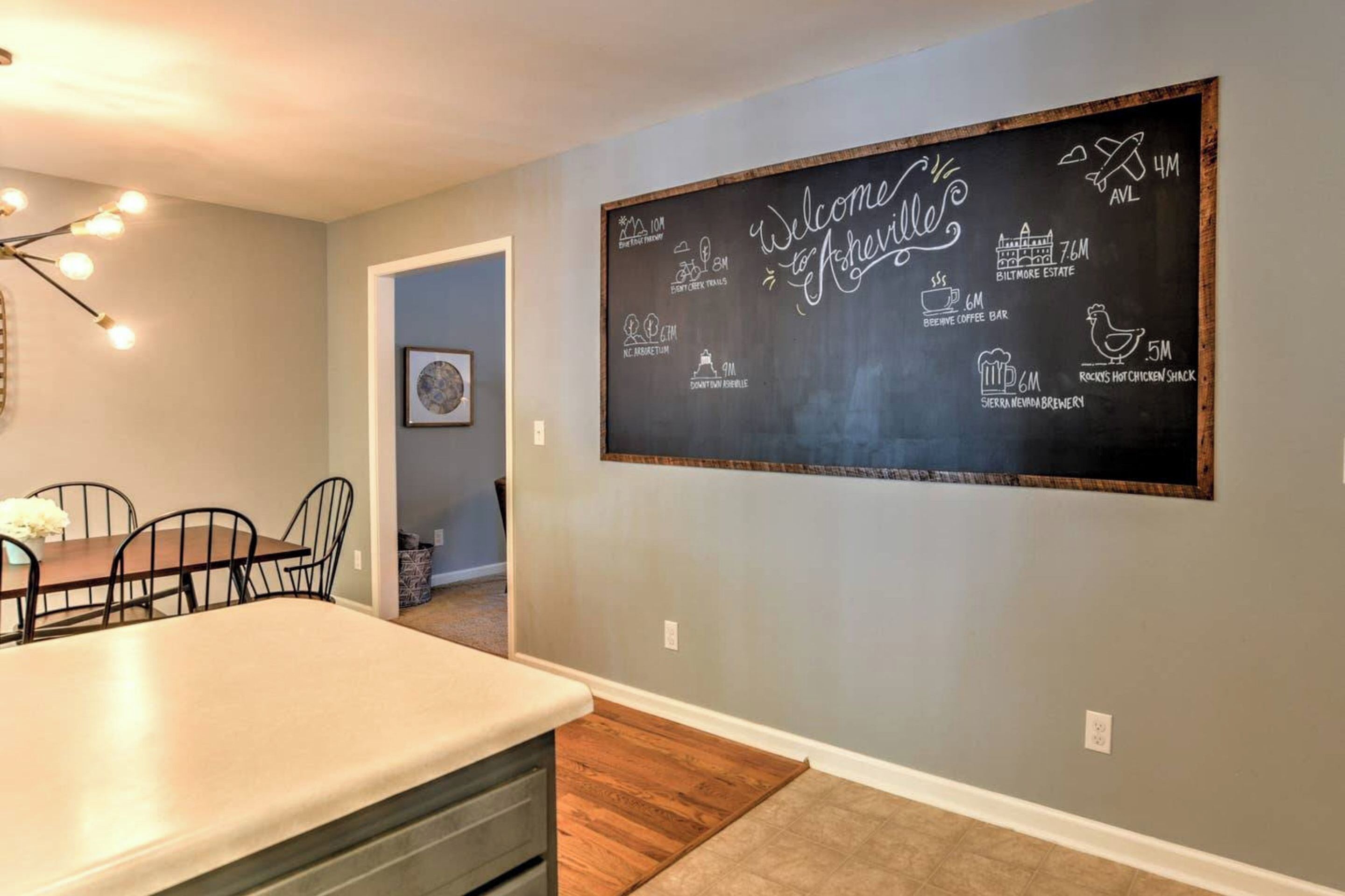 A dining area with a chalkboard wall displaying various business names and logos.