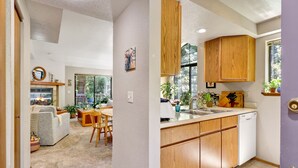 Une cuisine moderne avec des meubles en bois, un lave-vaisselle et une fenêtre agrémentée de plantes.