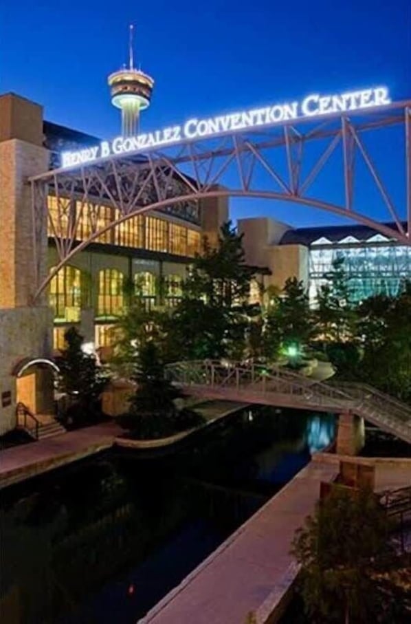 The Henry B. Gonzalez Convention Center with a prominent tower and a bridge over a water feature.