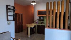 Une cuisine compacte équipée d’un four à micro-ondes, d’une petite table et d’un placard.