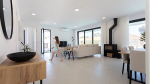 Una sala de estar moderna con sofá, televisor y chimenea.