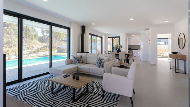 Una sala moderna con vista a la piscina, un comedor y una cocina.