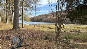 Un parc avec une sculpture en métal, un lac et des arbres.