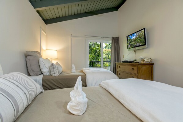 A hotel room with two beds, a bedside table with a lamp, a dresser, and a television on the wall. - Stunning Ocean Views! Renovated Wailea Ekolu 502 (Wailea)