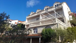 A multi-story building with balconies and a stone facade. - Sponga 2 Apartment with balcony and sea view (Polače)