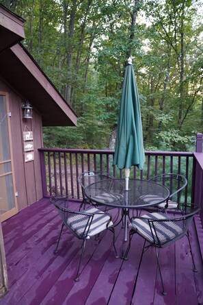 Enjoy al fresco dining on the deck surrounded by a lush forest.