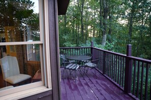 Enjoy outdoor dining or relaxation on this spacious deck overlooking a dense forest.