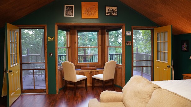A cozy room with a wooden ceiling, a large window, two chairs, and a bed. - Peaceful Smoky Mountain Cabin Near Cades Cove (Townsend)