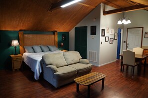 Relax in this inviting bedroom with a large bed, sofa, and dining area, perfect for unwinding.