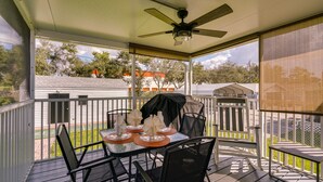 A covered outdoor patio with a table set for dining, chairs, and a ceiling fan. - Sunny Fort Myers Home w/ Screened-In Porch & Grill (Fort Myers)