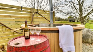 A wooden hot tub with a towel, a wine bottle, and two glasses on a barrel. - Unique Finger Lakes Converted Horse Barn w/ Patio! (Geneva)