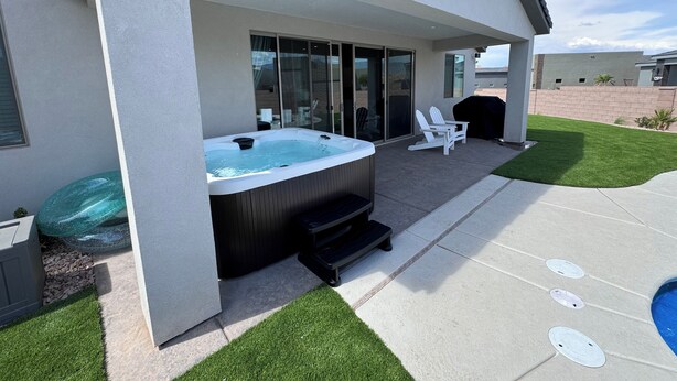 Une terrasse extérieure moderne dotée d’un jacuzzi, d’un espace salon et d’une piscine.