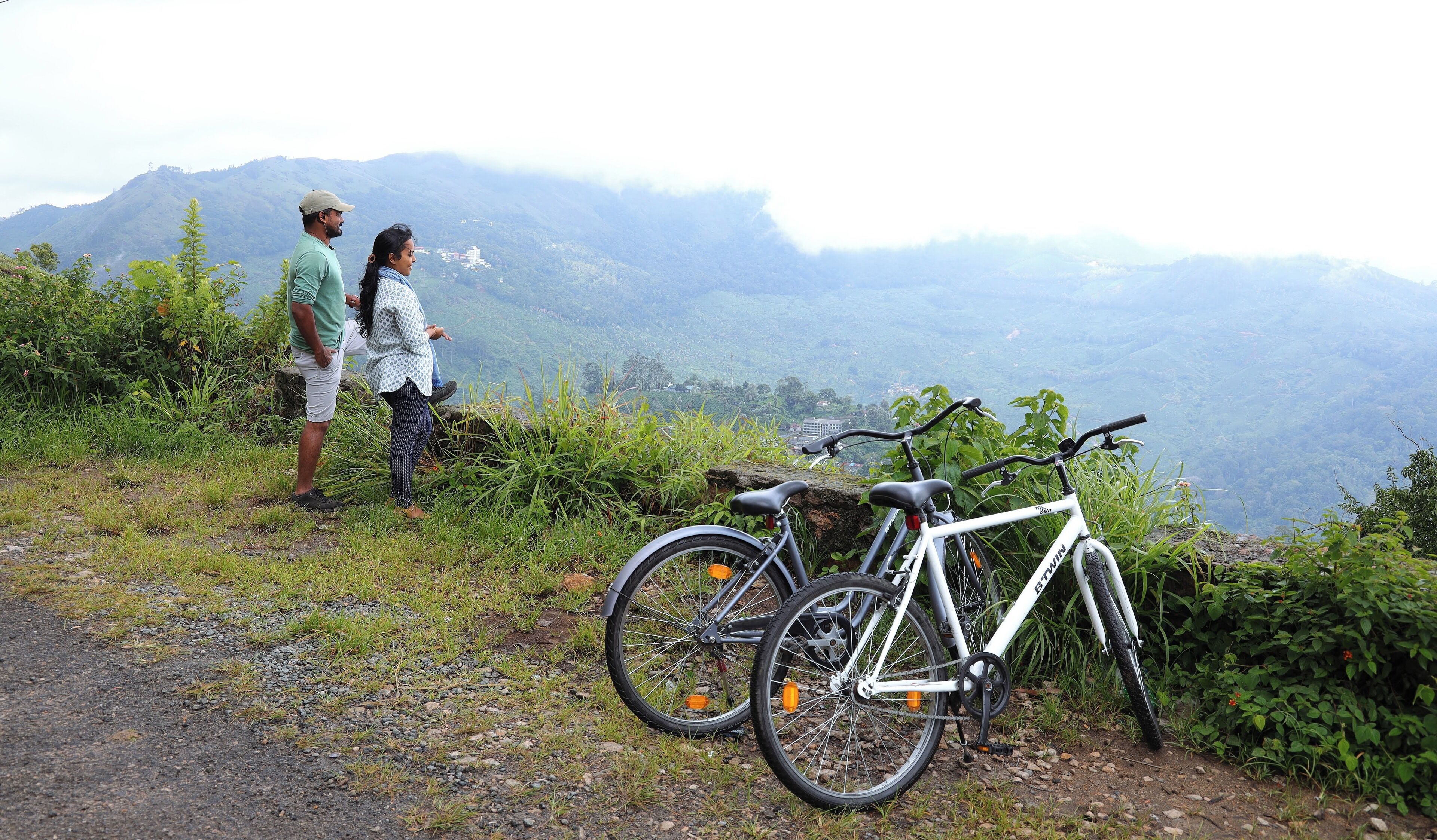 Una bicicleta estacionada en un sendero con un paisaje montañoso al fondo.