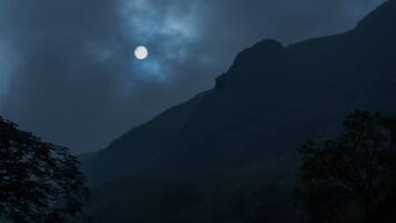 Un paisaje montañoso con una luna visible.